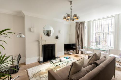 a living room with a couch and a fireplace at 56 Welbeck Street in London