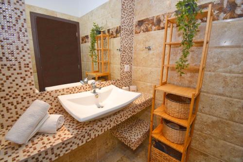 Potamos Superior Apartment في Potamós: حمام مع حوض ومرآة