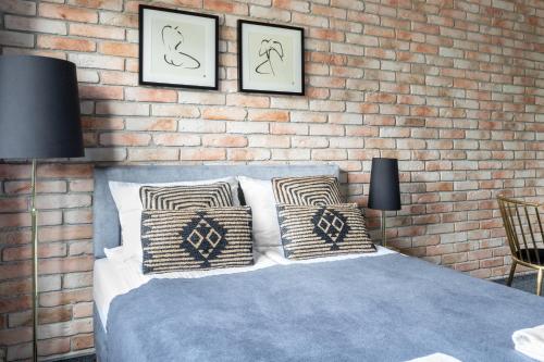 a bedroom with a brick wall and a bed with pillows at Przystań Stegna in Stegna