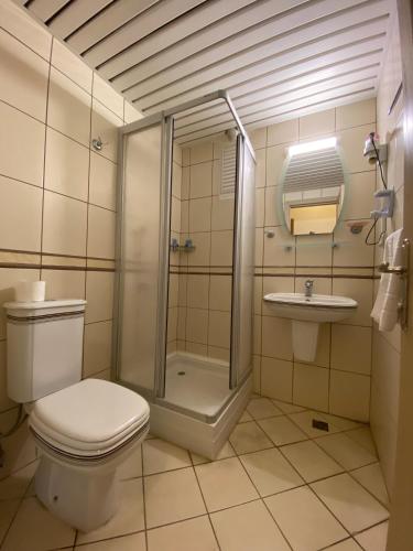 a bathroom with a shower and a toilet and a sink at Bliss Beach Hotel in Marmaris