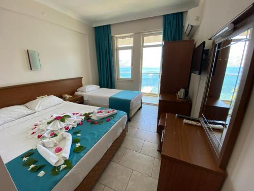 ein Hotelzimmer mit 2 Betten und einem TV in der Unterkunft B&B Yuzbasi Beach in Marmaris
