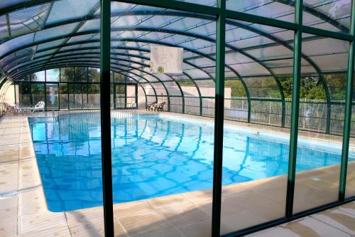 a large swimming pool with a glass wall at Village vacances du Haut-Bréda aux 7 Laux in La Ferrière