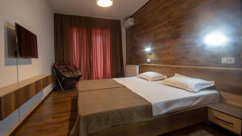 a bedroom with a bed and a red curtain at Check inn Delisi in Tbilisi City