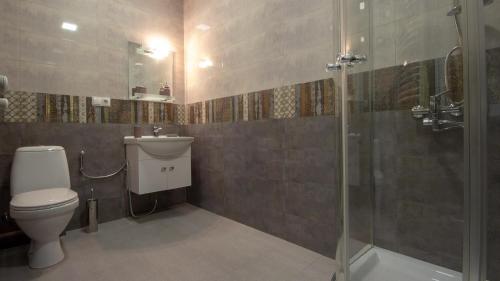 a bathroom with a toilet and a glass shower at Check inn Delisi in Tbilisi City
