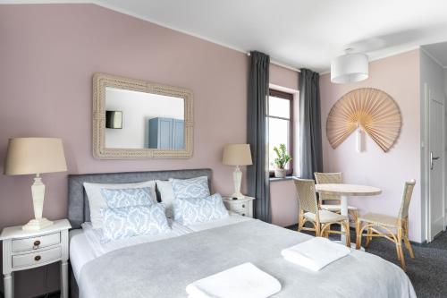 a bedroom with a bed with a mirror and a table at Przystań Stegna in Stegna