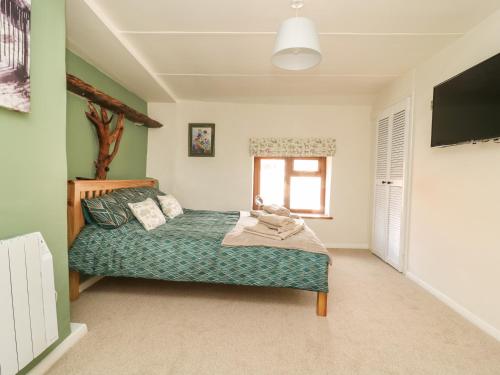 a bedroom with a bed and a television in it at Pollard Cottage in Northallerton