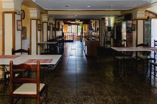 un ristorante con tavoli e sedie in una stanza di Hotel Castel a Canoas