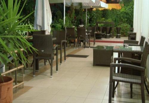 an empty restaurant with tables and chairs and umbrellas at Laodamia Hotel in Nea Anchialos