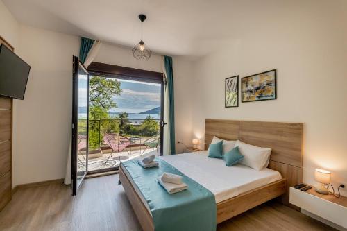 a bedroom with a bed and a balcony at Green Valley Apartments in Herceg-Novi