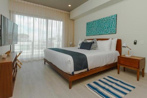 1 dormitorio con 1 cama grande y TV en The boat Playa del Carmen by Lockey, en Playa del Carmen