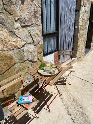 a picnic table and a bench next to a stone wall at Casa El calado in Viguera