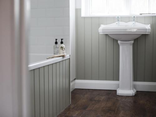 a bathroom with a sink and a bath tub next to a white sink at Lord High Admiral in Winchcombe