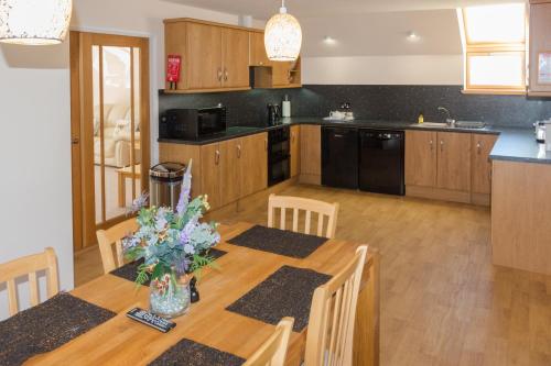 a kitchen with a wooden table with chairs and a dining room at Seaview Apartment in Keiss