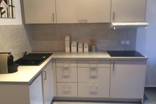 une cuisine avec des armoires blanches et un évier dans l'établissement C055-Bel Appartement au coeur du Suquet, à Cannes