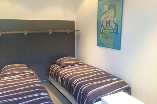 une chambre avec deux lits et un tableau au mur dans l'établissement C055-Bel Appartement au coeur du Suquet, à Cannes