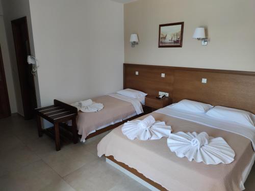 two beds in a hotel room with a piano at Filoxenia Hotel Monemvasia in Monemvasia