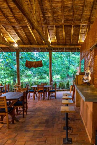 a restaurant with wooden tables and wooden chairs at Nativo Glamping in Barichara