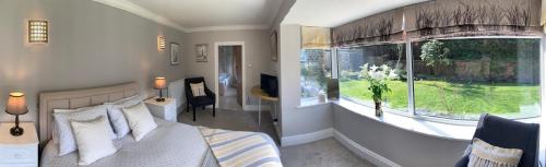 a bedroom with a bed and a large window at The Garden Suite in Harrogate