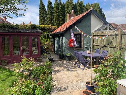 um jardim com uma mesa e um barracão em The Garden Suite em Harrogate