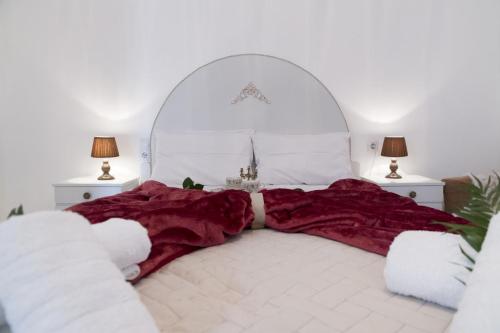 a bedroom with a large white bed with red blankets at Chryso Apartment in Kamilari