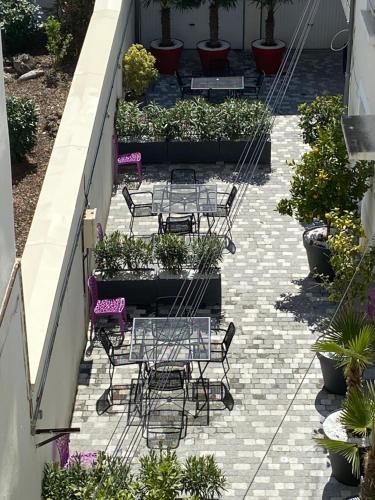 a patio with tables and chairs and potted plants at NID D AMOUR F1 40m2 calme RDC possibilité jacuzzi hammam in Chamalières