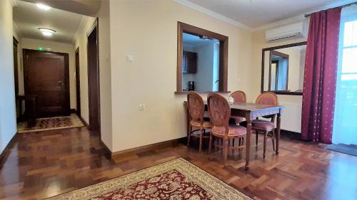 a dining room with a wooden table and chairs at Apartamenty Ucho Igielne in Sandomierz