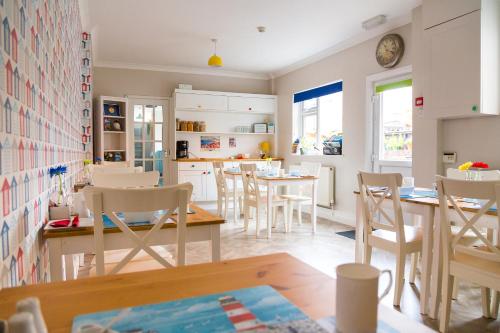 cocina y comedor con mesas y sillas en Kingsway Guesthouse - A selection of Single, Double and Family Rooms in a Central Location en Scarborough