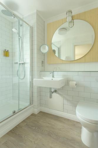 a bathroom with a shower and a sink and a mirror at Isle Of Mull Hotel and Spa in Craignure