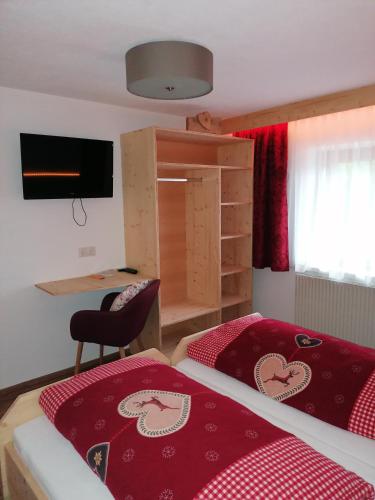a bedroom with a bed and a desk and a chair at Zachhof in Ellbögen