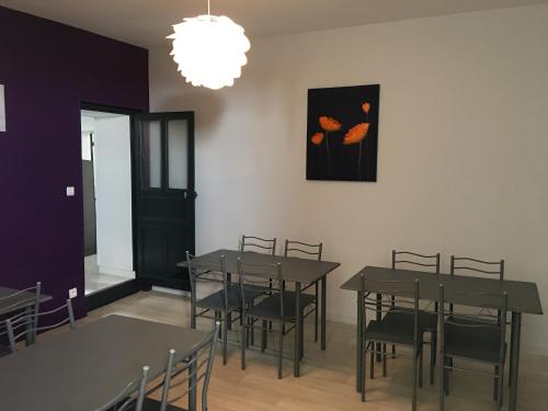 a dining room with tables and chairs and a picture on the wall at Le Clos D'isabeau in Les Épesses