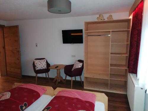 a bedroom with a bed and a table and chairs at Zachhof in Ellbögen
