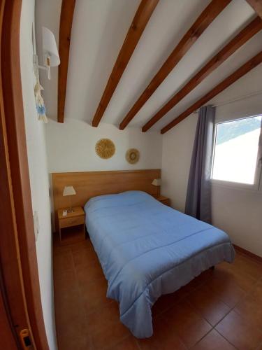 une chambre avec un lit bleu et une fenêtre dans l'établissement Appartement avec piscine vue mer et montagne, à San-Nicolao