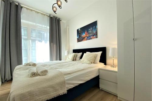 een slaapkamer met een groot bed en handdoeken bij erApartments Mennica Residence in Warschau