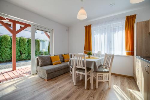a living room with a table and a couch at Purtulka pokoje klimatyzowane in Pobierowo