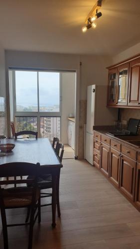 une cuisine avec une table et des chaises ainsi qu'une grande fenêtre dans l'établissement Bastia Appartement 3 chambres vue mer, à Bastia