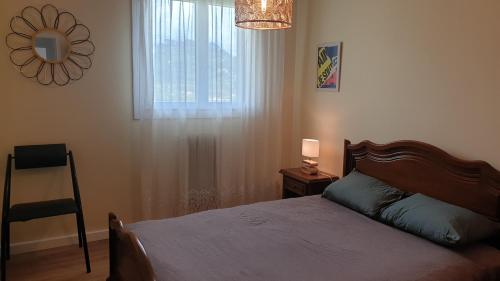 sypialnia z łóżkiem, oknem i krzesłem w obiekcie Bastia Appartement 3 chambres vue mer w Bastii