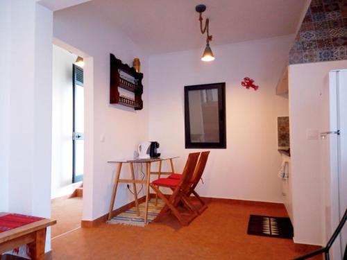 ein Esszimmer mit einem Tisch und einem roten Stuhl in der Unterkunft Lazy Lizard by the Ocean in Seixal