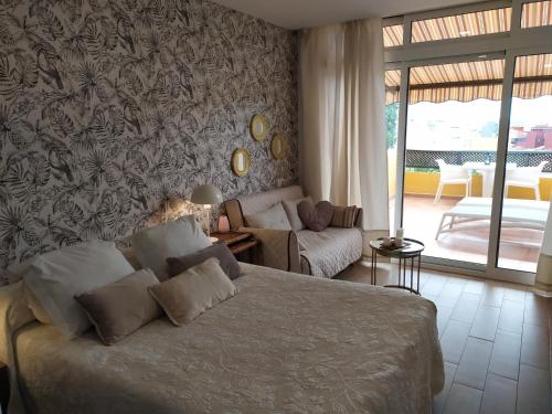 a bedroom with a bed and a living room at Atico junto al mar in Puerto de la Cruz
