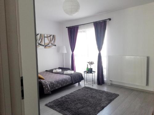 1 dormitorio con cama y ventana grande en Marlen’s Apartment, en Bucarest
