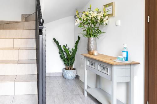 a bathroom with a console table and plants at Przystań Stegna in Stegna