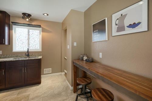 a kitchen with a bar with two stools and a window at @ Marbella Lane - 4BR Cozy & Comfy Northglenn in Northglenn