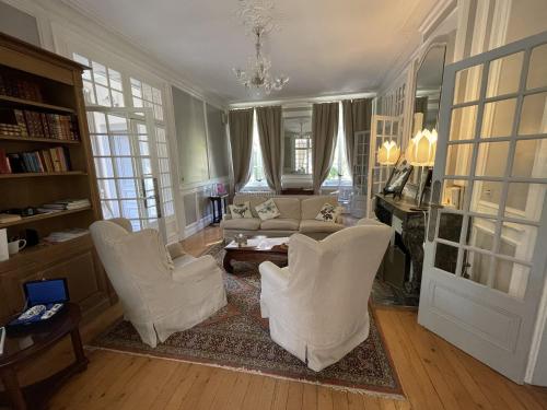 sala de estar con sillas blancas y sofá en Château de Noyelles – Baie de Somme en Noyelles-sur-Mer