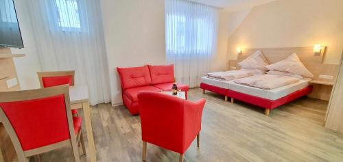 a bedroom with a red bed and a red chair at Hotel Da Sabino in Singen
