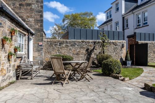 a patio with a table and chairs in front of a building at No1 Apartments & Bedrooms St Andrews - St Mary's in St. Andrews