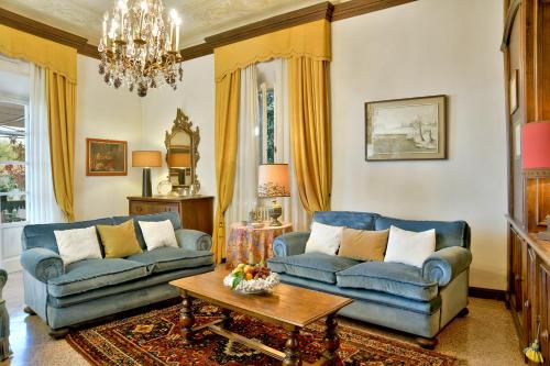 a living room with two blue couches and a table at Villa Carlotta con piscina in Lari