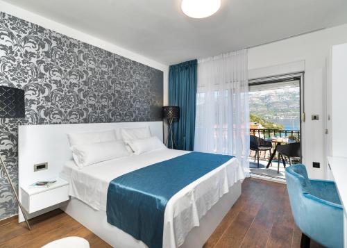 sypialnia z łóżkiem z niebieskim kocem i oknem w obiekcie WISH Apartments w Korčuli