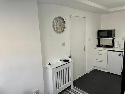 a white room with a clock on the wall at Wisteria Studio in London