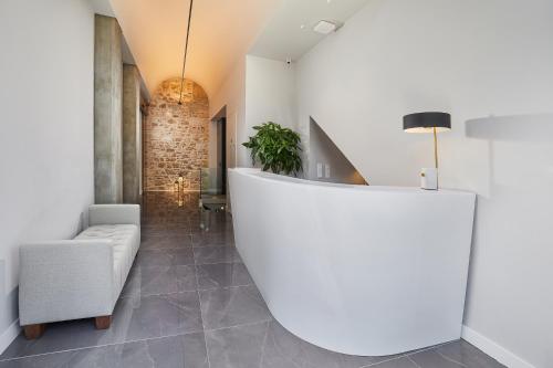 a living room with a white wall and a chair at MiraMe Athens Boutique Hotel in Athens