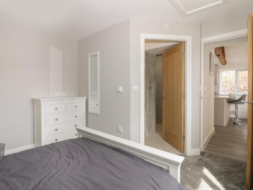 a white bedroom with a bed and a bathroom at Laurel Farm in Malton