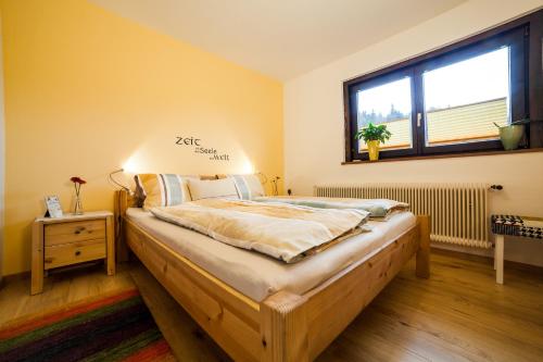a bedroom with a large bed with a window at Haus Hartl in Saalfelden am Steinernen Meer